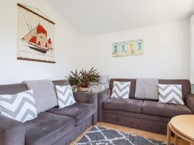 A living room with two sofas with chevron cushions and a plant between them at 224 Atlantic Bays in St Merryn