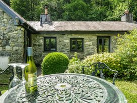 A table and chairs with wine and glasses at Tyn Y Ffynnon in Betws-Y-Coed
