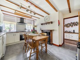 A kitchen with a dining table and chairs at Tyn Y Ffynnon in Betws-Y-Coed