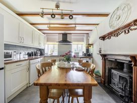 A kitchen with a table and chairs at Tyn Y Ffynnon in Betws-Y-Coed