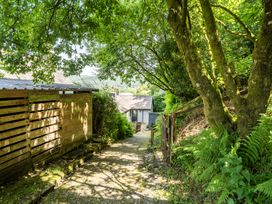 A pathway leading to a house with trees and a fence at Tyn Y Ffynnon in Betws-Y-Coed