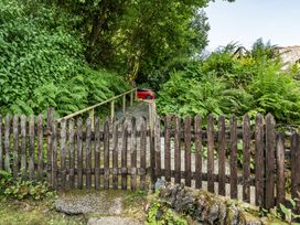 A pathway with a wooden fence and a car at Tyn Y Ffynnon in Betws-Y-Coed