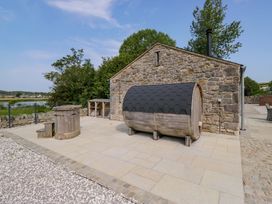 An outdoor area with a hot tub and wooden barrel at Limestone in Great Urswick