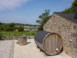An outdoor area with a wooden barrel sauna and hot tub at Limestone in Great Urswick
