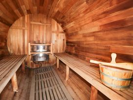 A sauna with wooden benches and a stove at Limestone in Great Urswick