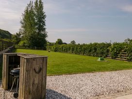 A garden with a grill and wooden cabinet at Limestone in Great Urswick