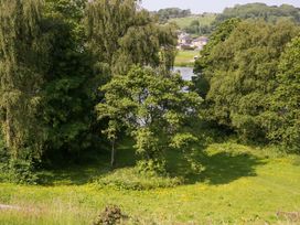 A landscape with trees and water near houses at Limestone in Great Urswick