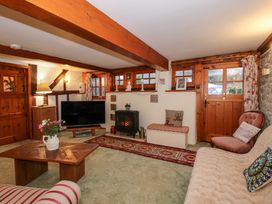 A living room with wooden beams a television a coffee table and a wood stove at Tawny Owl Barn in Leintwardine
