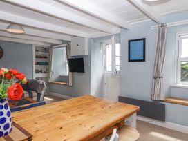 A dining room with a wooden table and chairs at 2 Cliff Cottages West Portholland near Gorran Haven