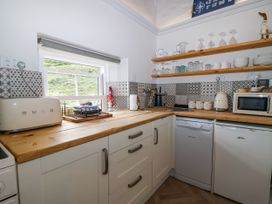 A kitchen with appliances and dishes on the counter at 2 Cliff Cottages West Portholland near Gorran Haven