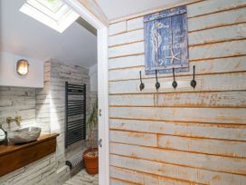 A bathroom with a sink and towel rack at 2 Cliff Cottages West Portholland near Gorran Haven