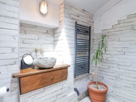 A bathroom with a stone sink and towel rack at 2 Cliff Cottages in West Portholland near Gorran Haven