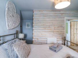 A bedroom with a bed and wall art at 2 Cliff Cottages West Portholland near Gorran Haven