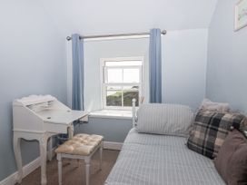 A bedroom with a desk, chair, and a window at 2 Cliff Cottages West Portholland near Gorran Haven