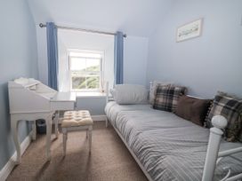 A bedroom with a bed and desk at 2 Cliff Cottages West Portholland near Gorran Haven