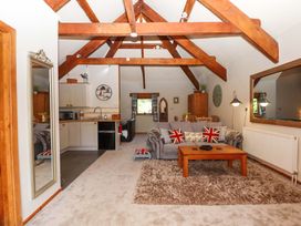 A living room with a sofa and kitchen area at Little Torr in Drewsteignton