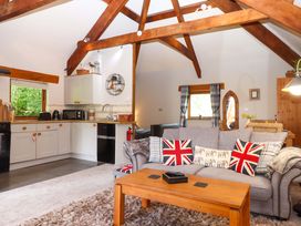 A living room with a sofa and kitchen area at Little Torr in Drewsteignton