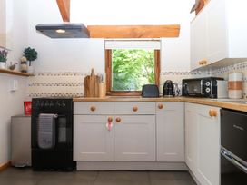 A kitchen with appliances and a window at Little Torr in Drewsteignton