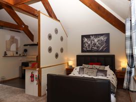 A bedroom with a bed and kitchen area at Little Torr in Drewsteignton