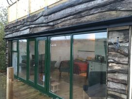 An outdoor view of a wooden structure with large glass doors at The Sett on the Wharfe Skipton