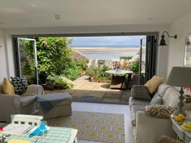 A living room with a view of a garden and outdoor furniture at Mariners Cottage in Appledore