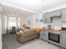 A living room with a sofa and kitchen units at 76A Mackworth Road Porthcawl