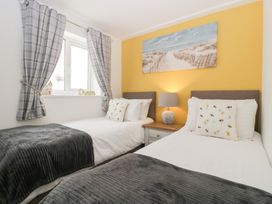 A bedroom with two beds and wall art at 76A Mackworth Road in Porthcawl