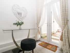 A hallway with a glass table and a stool at 76A Mackworth Road Porthcawl