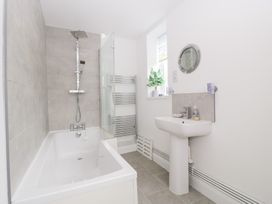 A bathroom with a bathtub, shower, sink, and towel rail at 76A Mackworth Road, Porthcawl