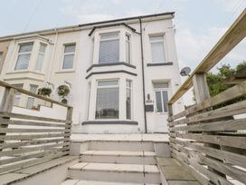A house exterior with stairs and planters at 76A Mackworth Road in Porthcawl