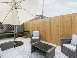 A garden with furniture and an umbrella at 76A Mackworth Road Porthcawl