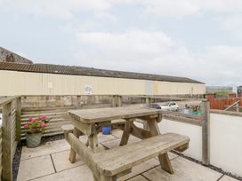 An outdoor area with a wooden table and benches at 76A Mackworth Road, Porthcawl