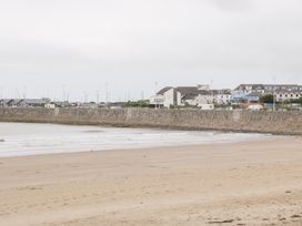 A beach with water and buildings in the distance at 76A Mackworth Road Porthcawl