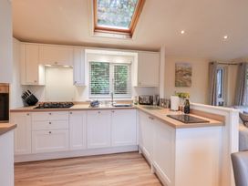 A kitchen with cabinets and appliances at Acorn Bank Lodge, L 55, Fallbarrow Park near Bowness-On-Windermere