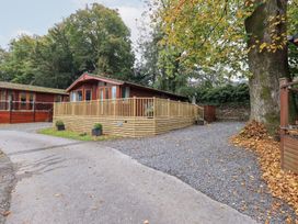 An outdoor area with a lodge and decking at Buttermere Lodge near Glade 5, Fallbarrow Park near Bowness on Windermere