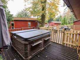 An outdoor area with a hot tub and decking at Buttermere Lodge in Glade 5, Fallbarrow Park near Bowness on Windermere