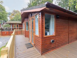 An outdoor area with a cabin and decking at Buttermere Lodge, Glade 5, Fallbarrow Park near Bowness on Windermere