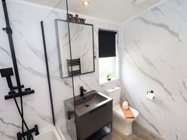 A bathroom with a shower, sink and toilet at Rydal Lodge Grasmere 24, White Cross Bay near Windermere