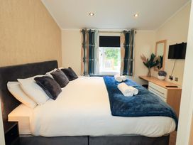 A bedroom with a large bed and furnishings at Rydal Lodge Grasmere 24, White Cross Bay near Windermere