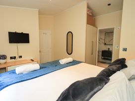 A bedroom with a bed, television, and bathroom access at Rydal Lodge in Grasmere 24, White Cross Bay near Windermere