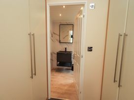 A bathroom with a mirror and sink at Rydal Lodge, Grasmere 24, White Cross Bay near Windermere