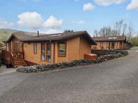 Two wooden cabins surrounded by stone walls at Elder Lodge Kirkstone 5 Limefitt Park near Windermere