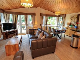 A living room with a sofa and television at Birthwaite Lodge Fellside 6 Limefitt Park near Windermere