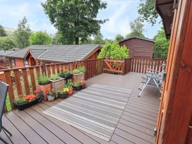 A deck with planters and chairs at Birthwaite Lodge, Fellside 6, Limefitt Park near Windermere