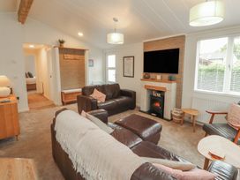 A living room with a sofa and television at Beech Grove Lodge Glade 17, Fallbarrow Park near Bowness on Windermere
