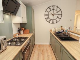 A kitchen with stove and sink at Beech Grove Lodge, Glade 17, Fallbarrow Park near Bowness on Windermere