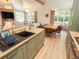A kitchen with a dining table and chairs at Beech Grove Lodge, Glade 17, Fallbarrow Park near Bowness on Windermere