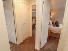 A hallway with doors leading to bedrooms at Beech Grove Lodge, Glade 17, Fallbarrow Park near Bowness on Windermere