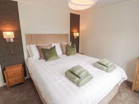 A bedroom with a bed and pillows at Beech Grove Lodge, Glade 17, Fallbarrow Park near Bowness on Windermere