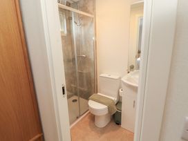 A bathroom with shower, toilet, and sink at Beech Grove Lodge in Glade 17, Fallbarrow Park near Bowness on Windermere